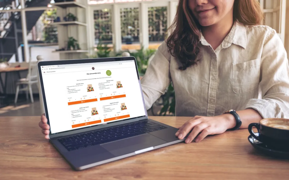 Laptop op tafel met Ekomenu website klaar om de kortingscode in te voeren