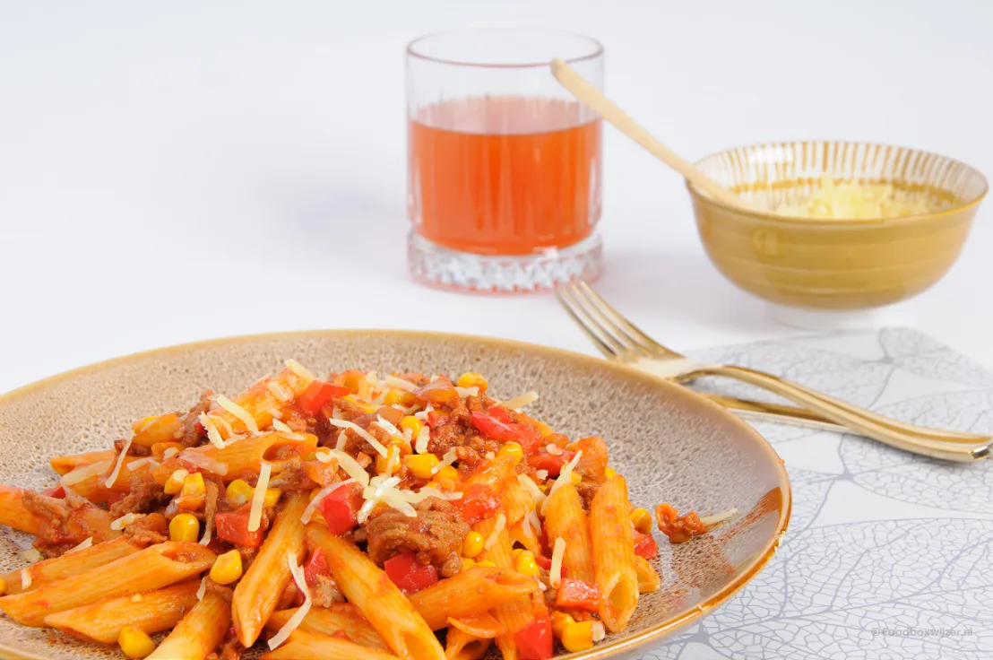 Het resultaat van de snelle Mexicaanse pasta serveren we met extra geraspte kaas