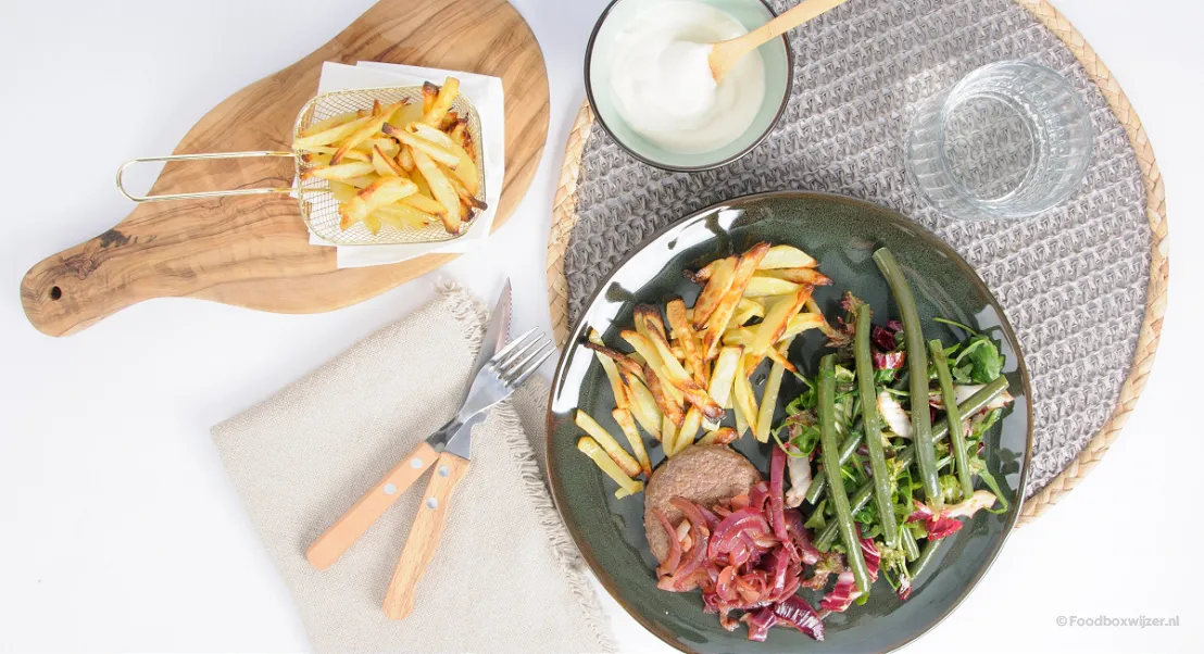 Ons bereide gerecht van Hellofresh op tafel geserveerd met Duitse biefstuk en sperziebonensalade