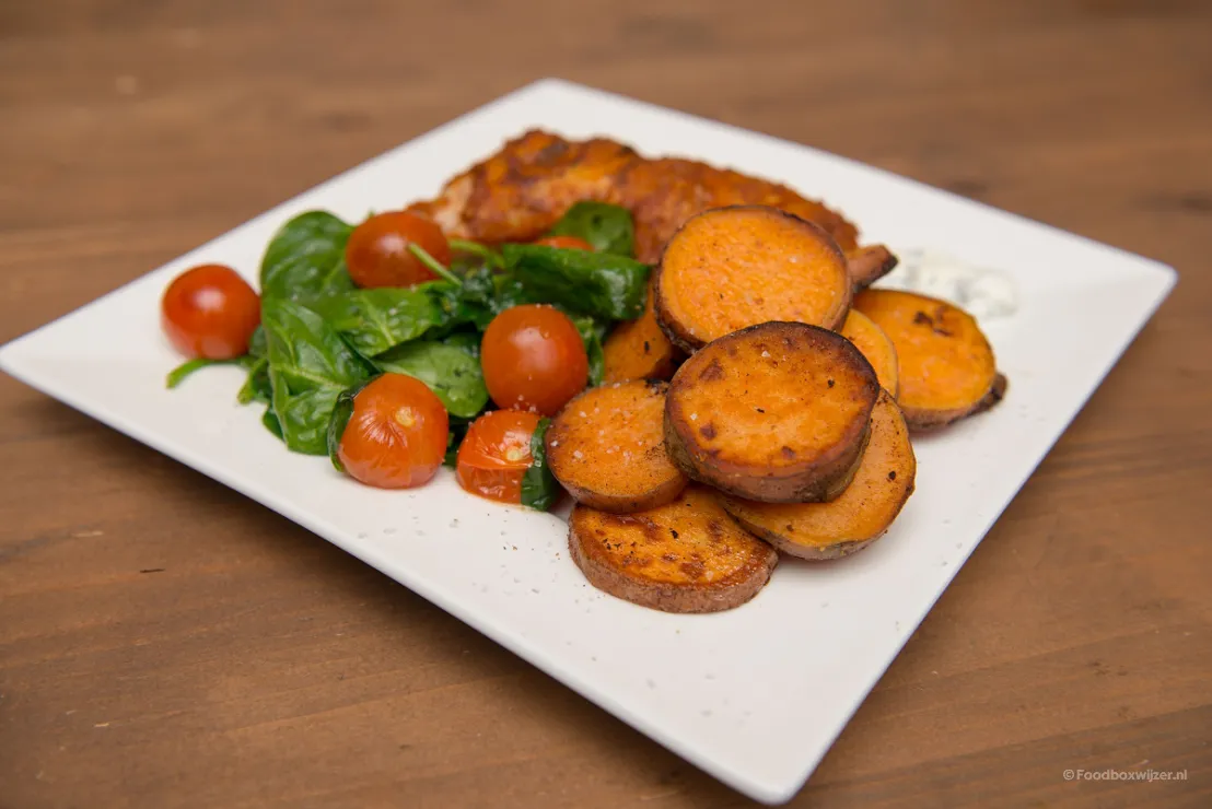 Op het bord de kiptandoori met zoete aardappel
