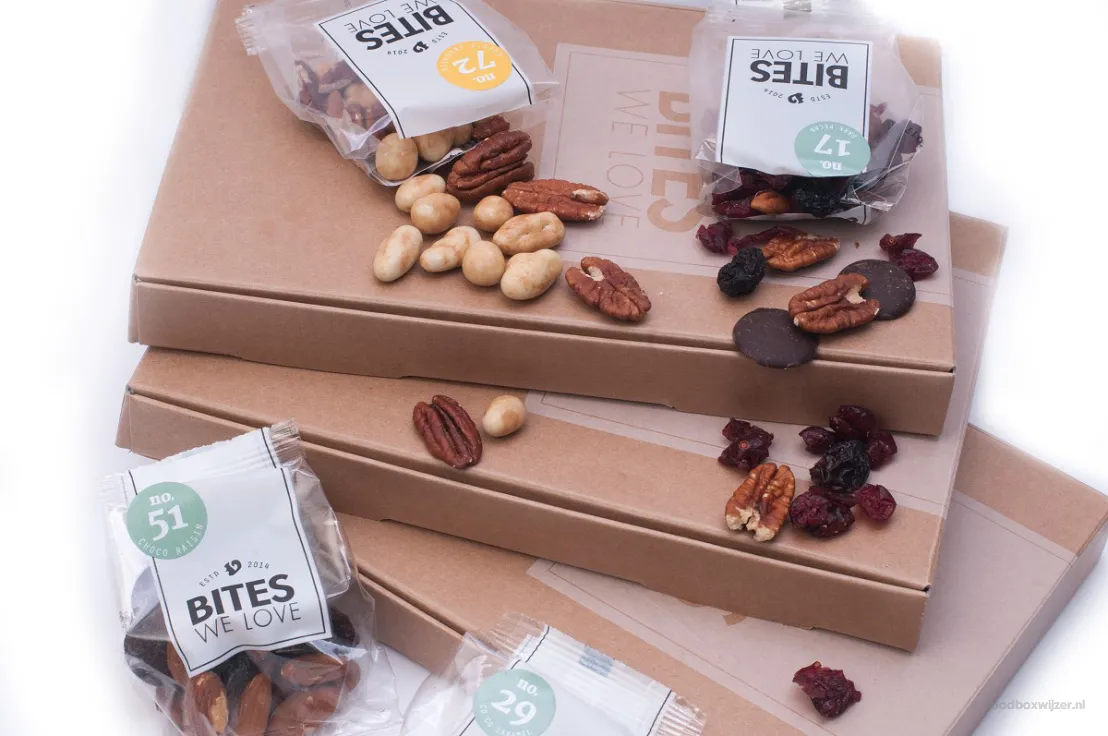 Doosjes van Bites We Love met zakjes nootjes en chocolaatjes erop