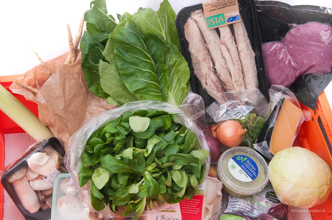 Close-up van de oranje krat van Beebox met alle inhoud voor het koken van koolhydraatarme gerechten