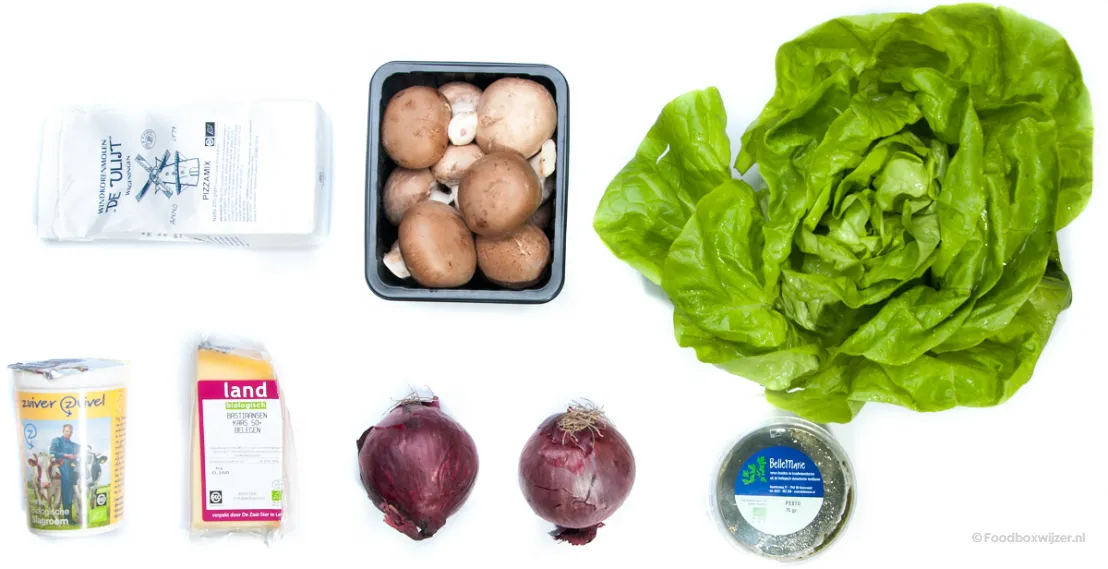 De ingrediënten voor de pizza pesto met champignons en rode uien