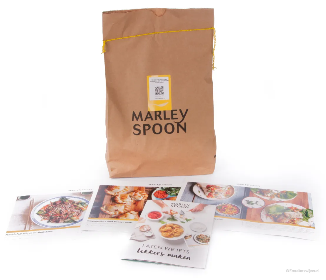 Een Marley Spoon zak met een gerecht erin en de receptkaarten daarvoor