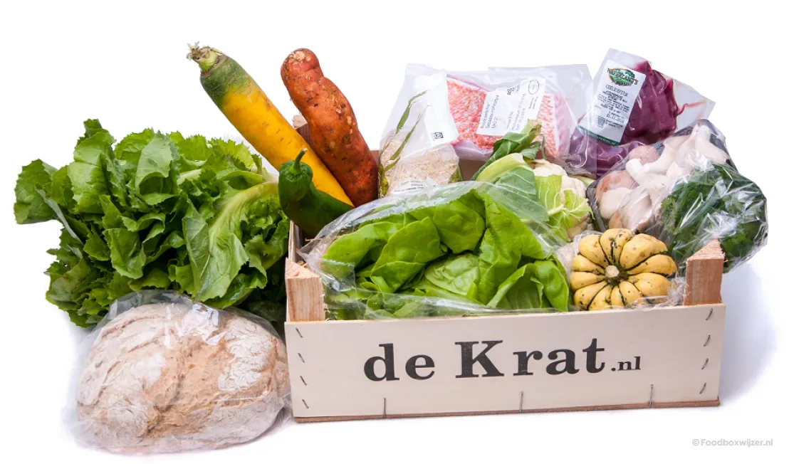 Een kratje van de Krat met inhoud zoals verse groenten, vis en een brood