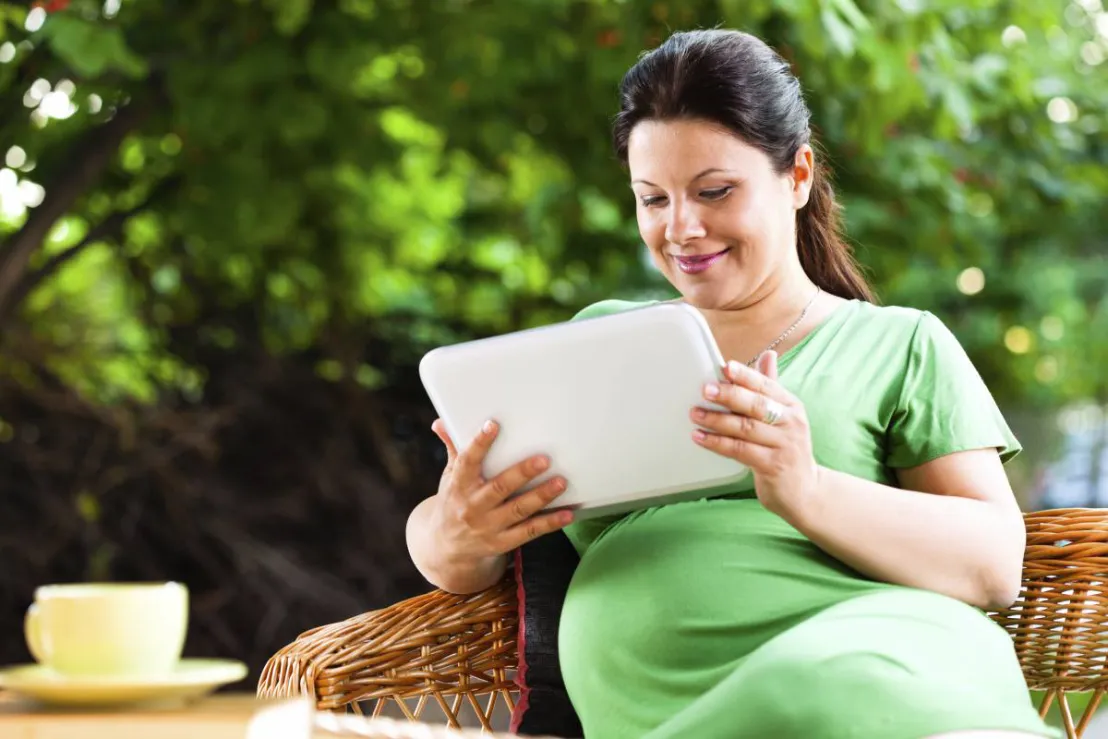 Zwangere vrouw met tablet die een maaltijdbox aan het bestellen is
