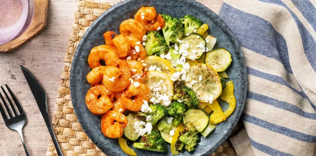 Ketogeen gerecht op een bord met harissa garnalen en gegrilde groenten