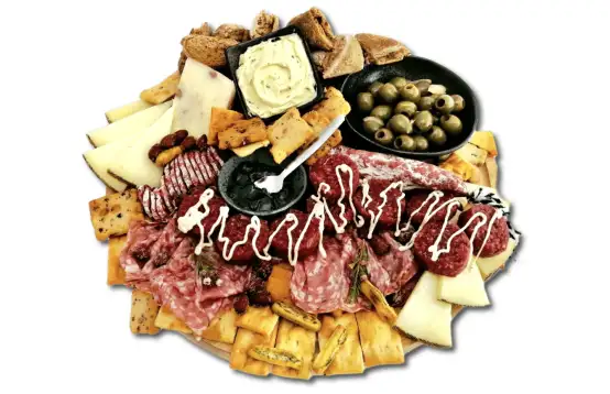 Een goedgevulde borrelplank met verse kaasjes, worst, toastjes en sausjes