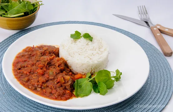 Hongaarse goulash bereidt met een verspakket van AH met rundvlees en rijst geserveerd op een wit bord