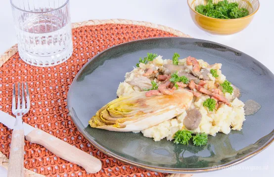 Een gerecht op tafel met veel groente zoals pastinaak, witlof en oesterzwammen waarmee een stamppot is gemaakt