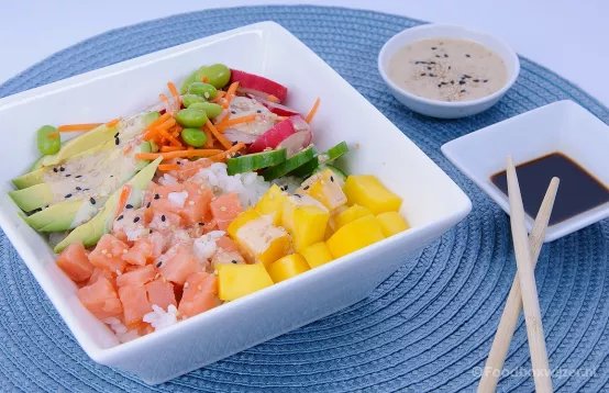 Een kleurige poke bowl gemaakt met het verspakket van Albert Heijn met zalmblokjes, avocado en sojaboontjes