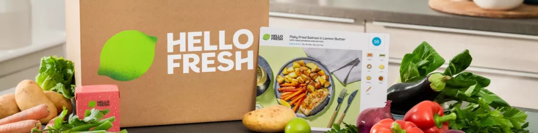 Hellofresh maaltijdbox op een aanrecht met daaromheen allerlei verse producten om mee te gaan koken