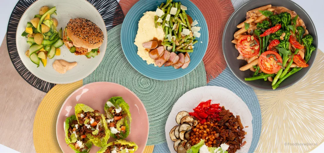 5 borden met onderleggers met daarop verschillende gerechten uit de maaltijdbox van green chef