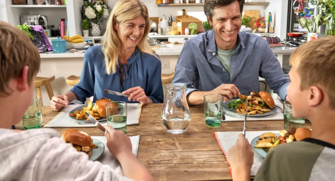 Gezin aan tafel met hellofresh gerechten die ook kindvriendelijk zijn