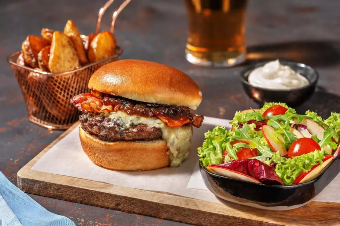 Hellofresh gerecht met een hamburger met blauwe kaas en spek met daarnaast een salade met appel